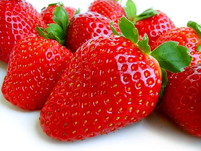 a few bright red 'All Star' strawberries with green tops against a white background