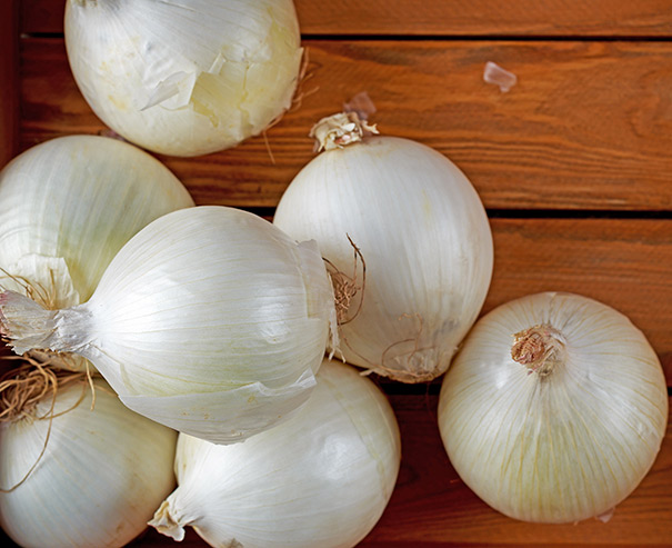 white onions on a wooden surface