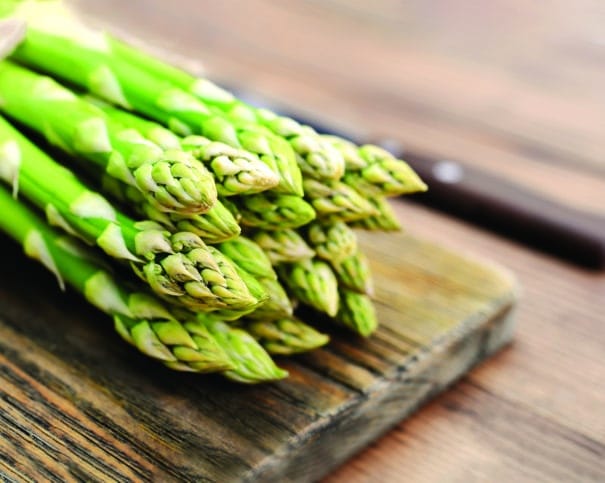 Bunch of asparagus Mary Washington on wooden background closeup