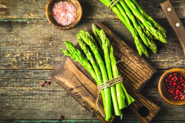 branches of fresh green asparagus Mary Washington on wooden background, top view