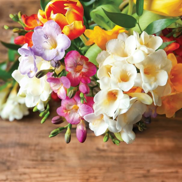 Top-down view of a Freesia bouquet on a wooden table